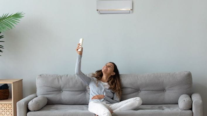 Mujer disfrutando de un aparato de aire acondicionado silencioso