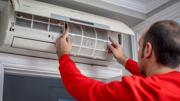 Técnico de HomeServe colocando un filtro en el aparato de aire acondicionado