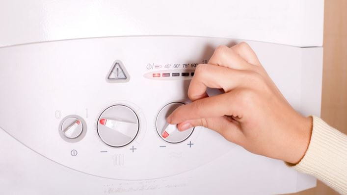 Mujer ajustando la temperatura del termo eléctrico