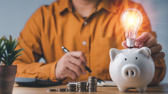 Concepto de ahorro con una calculadora y una bombilla