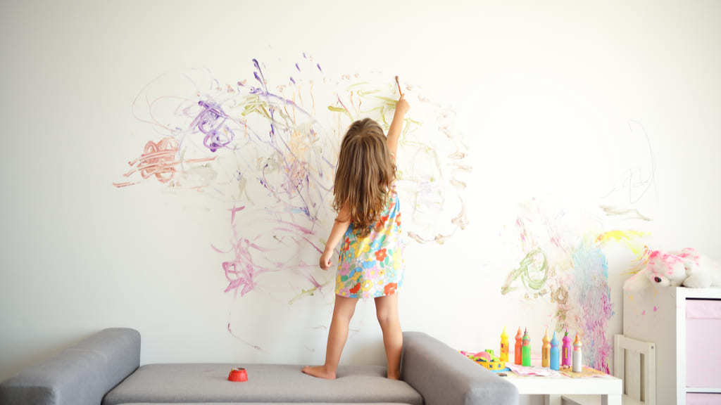 Niña pintando con rotulador en la pared
