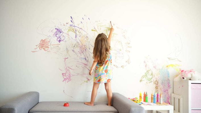 Niña pintando con rotulador en la pared