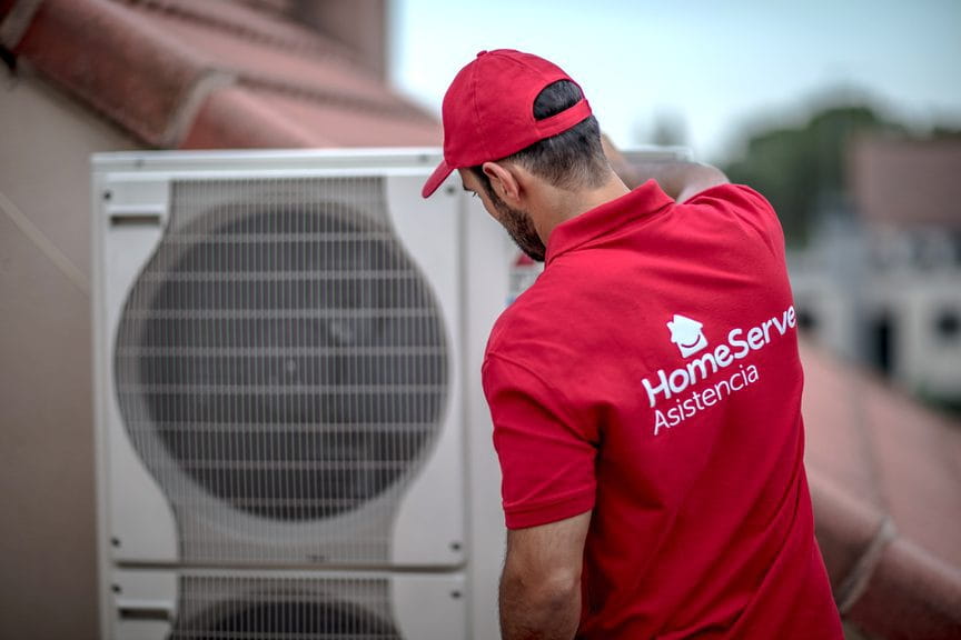 Técnico de HomeServe reparando un aire acondicionado de bomba de calor