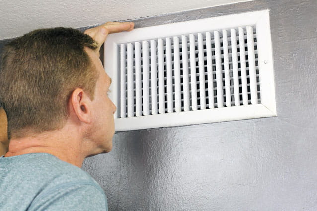 Técnico de HomeServe reparando un aire acondicionado por conductos
