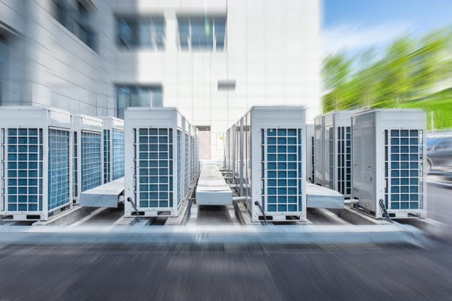 Varias unidades exteriores de aparatos de aire acondicionado ubicadas en el suelo