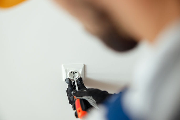 Un electricista de HomeServe trabajando para pasar de una instalación monofásica a una trifásica