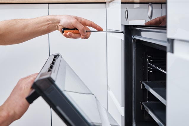 Técnico de HomeServe reparando un horno de cocina empotrado