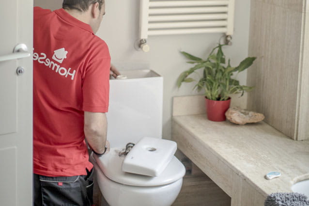Fontanero de HomeServe limpiando con Bicarbonato de sodio el sarro del inodoro
