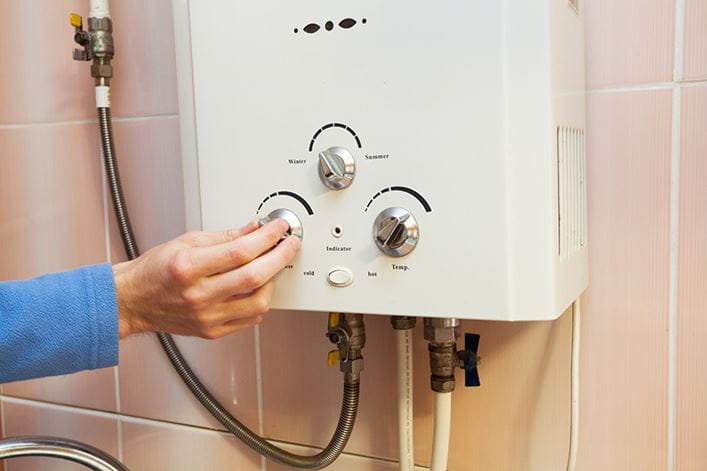 mano de mujer preparando ducha con agua climatizada por un calentador de gas o electrico