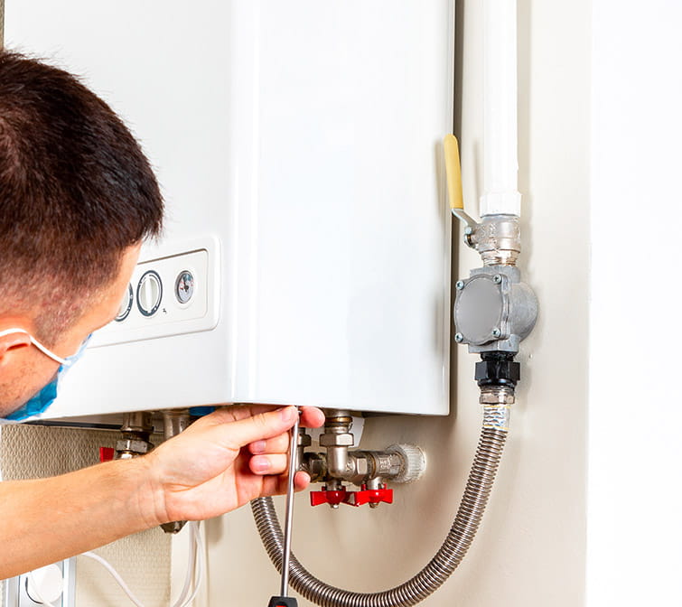 técnico de reparación de calentador de gas de HomeServe en la casa de un cliente