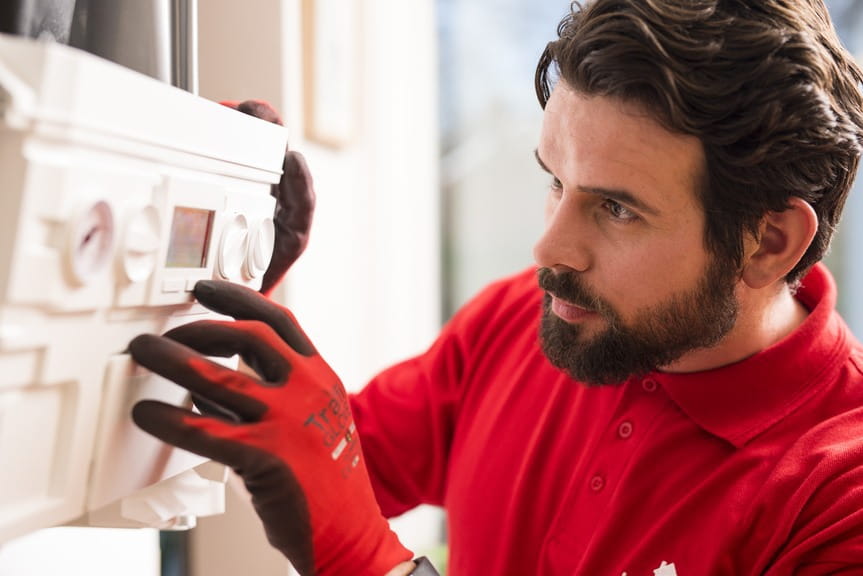 técnico de calefacción de HomeServe arreglando un calentador de agua de gas