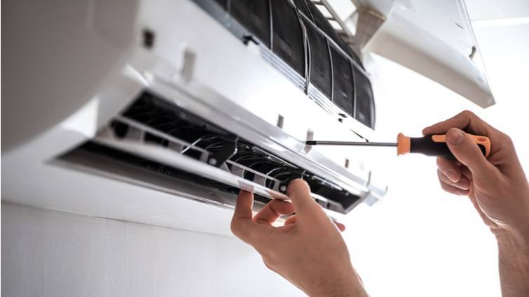 Hombre quitando tornillos para desmontar un split