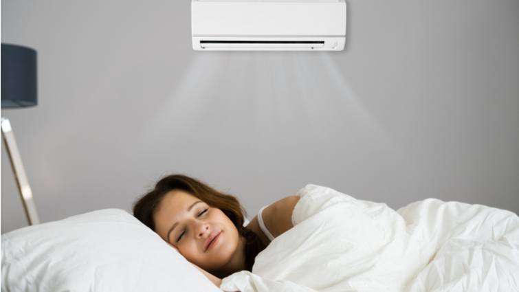 Mujer durmiendo con un aparato de aire acondicionado silencioso encendido