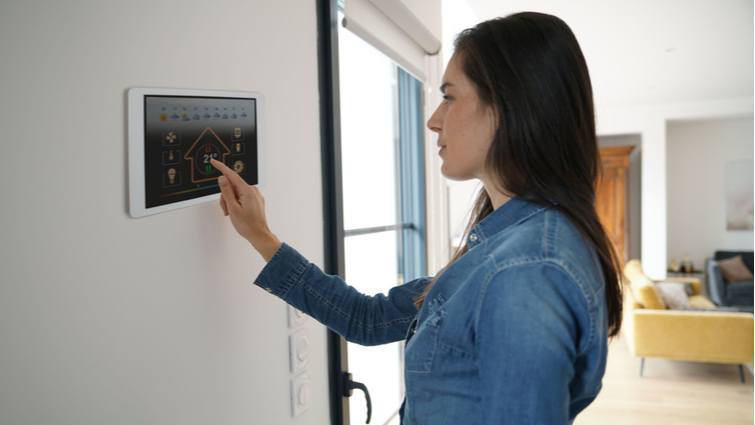 Mujer programando el termostato del aire acondicionado