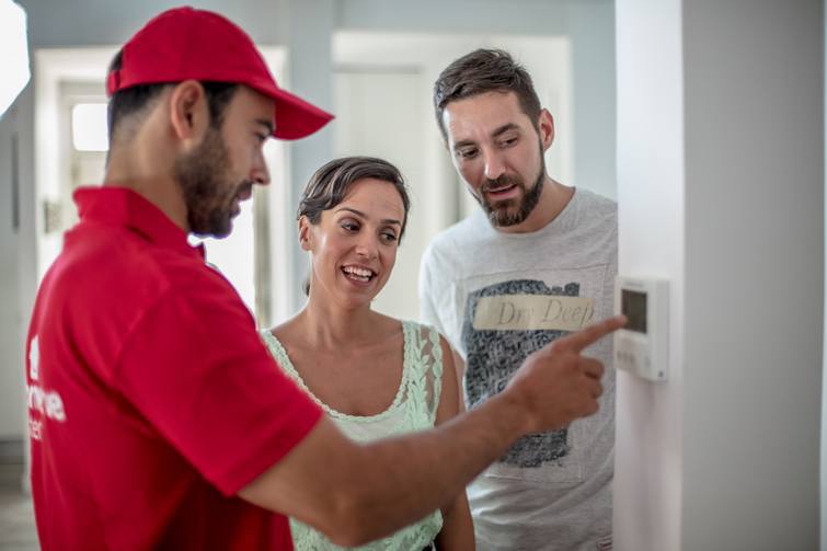 Técnico de HomeServe asesorando sobre aire acondicionado a una pareja