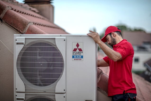 Técnico de HomeServe instalando un compresor de aire acondicionado