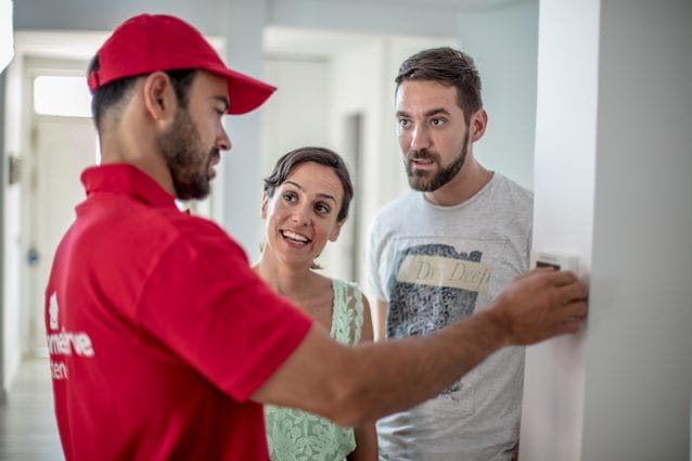 Técnico en aire acondicionado de HomeServe con unos clientes