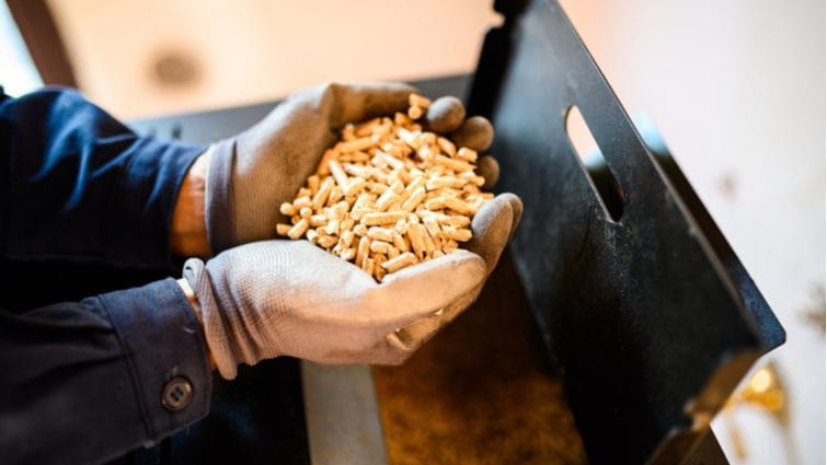 Manos de hombre cargando una estufa de pellets