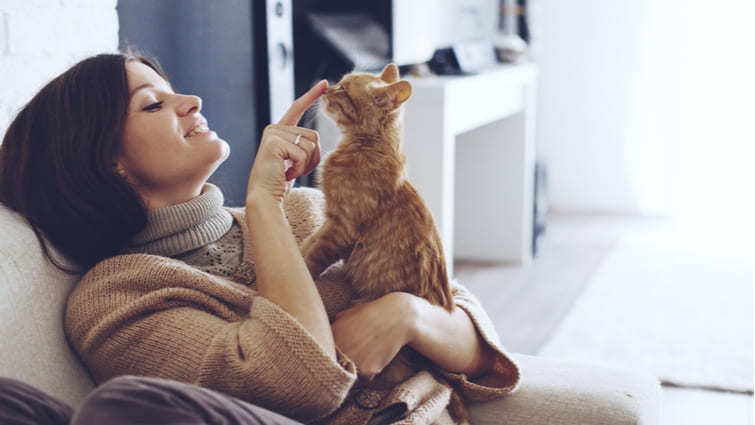 Mujer con un gato disfrutando de la temperatura de su hogar