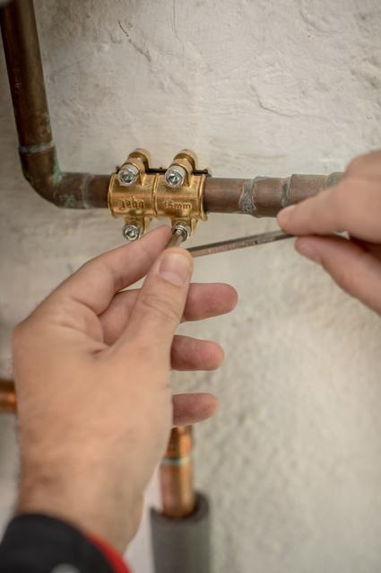 Profesional de HomeServe revisando los tubos de la calefacción