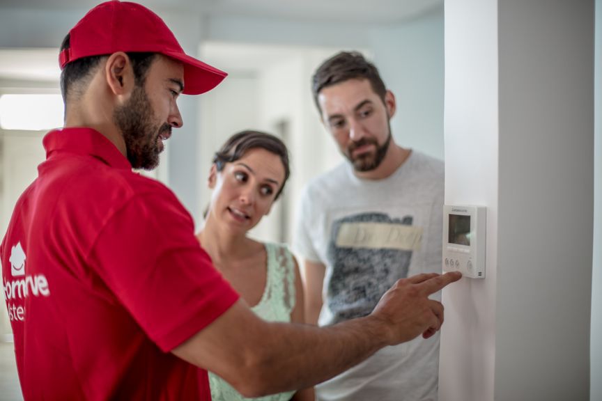 Técnico de HomeServe enseñando a unos clientes el funcionamiento del termostato