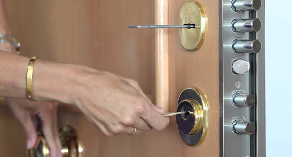 mujer abriendo puerta con llave en cerradura