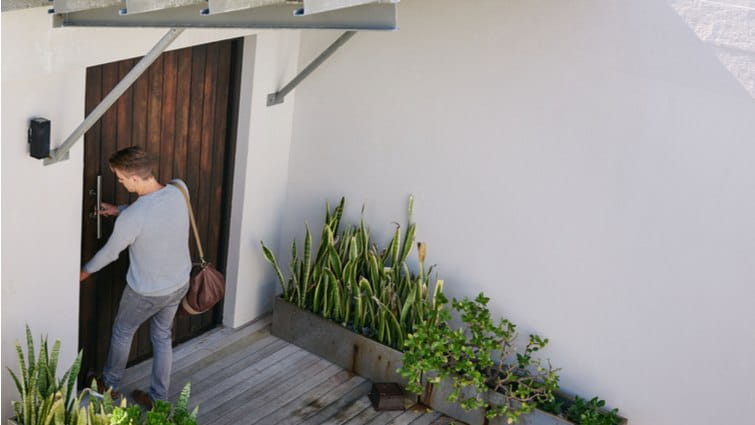 Un hombre intenta abrir la puerta de su vivienda