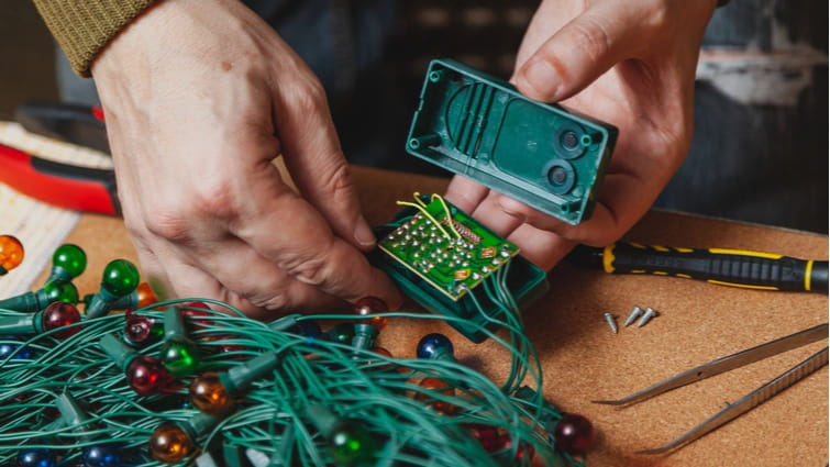 Hombre arreglando las luces de Navidad