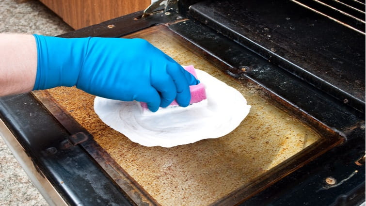 Hombre limpiando un horno con bicarbonato