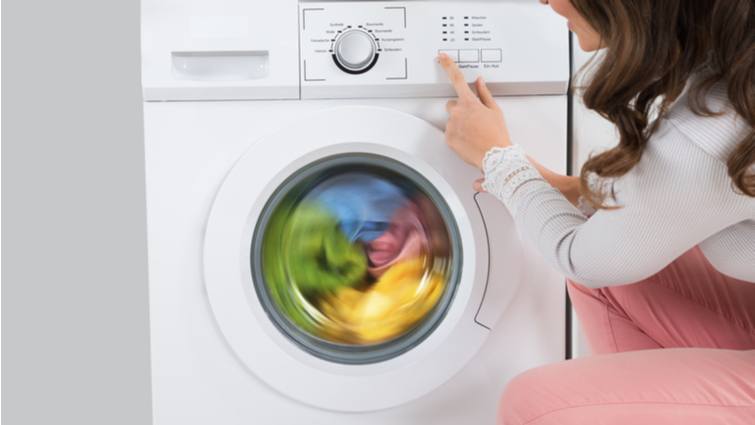Mujer eligiendo un programa de lavado para ropa de color