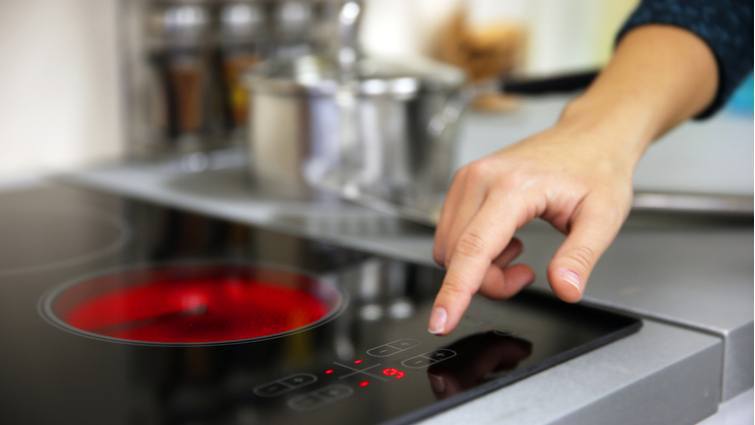 Mujer encendiendo una vitrocerámica