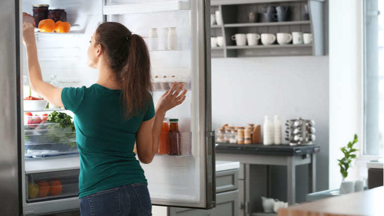 Mujer sacando comida de un frigorífico