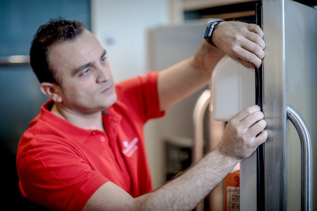 Profesional de HomeServe arreglando un frigorífico