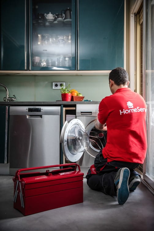 Profesional de HomeServe arreglando una lavadora