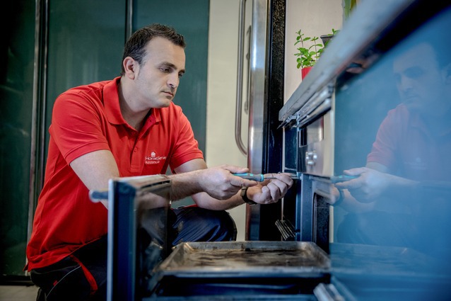 Técnico de HomeServe arreglando un horno eléctrico