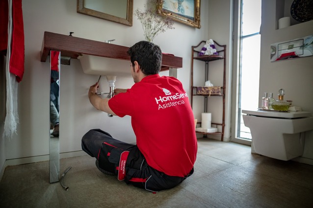 Fontanero de HomeServe desatascando el sifón de un lavabo