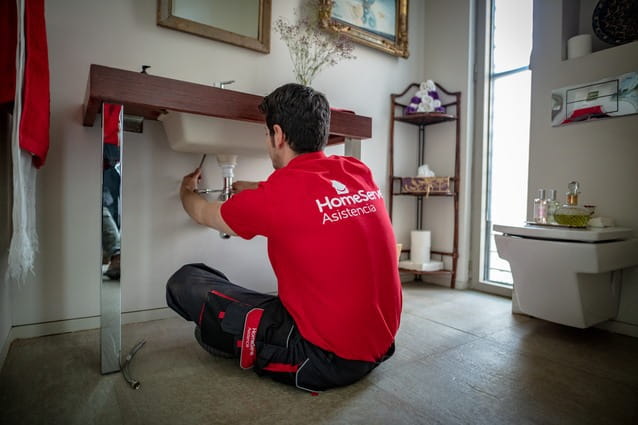 Fontanero de HomeServe reparando un grifo en el baño