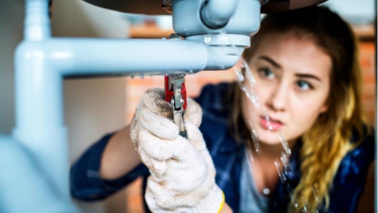 Mujer reparando una fuga de agua