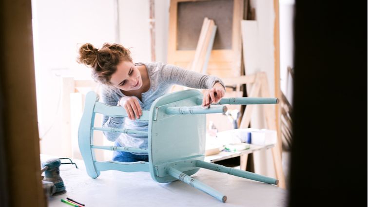 Mujer lijando una silla