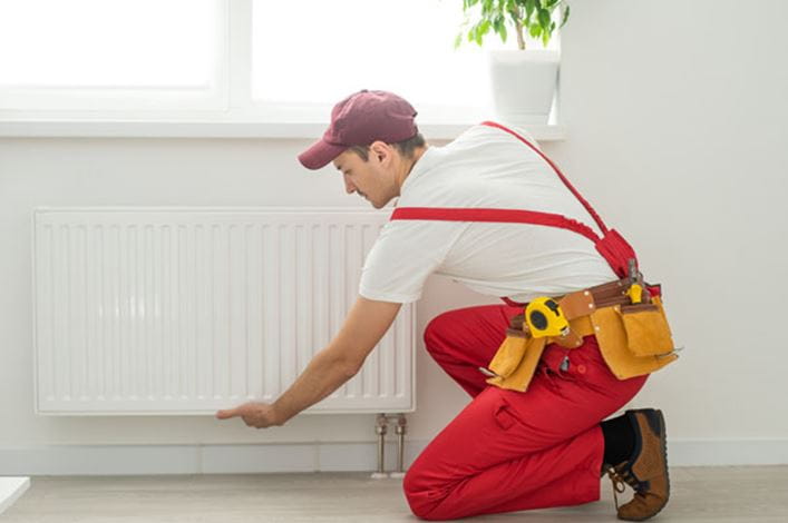 técnico de instalación de radiadores de HomeServe purgando un radiador
