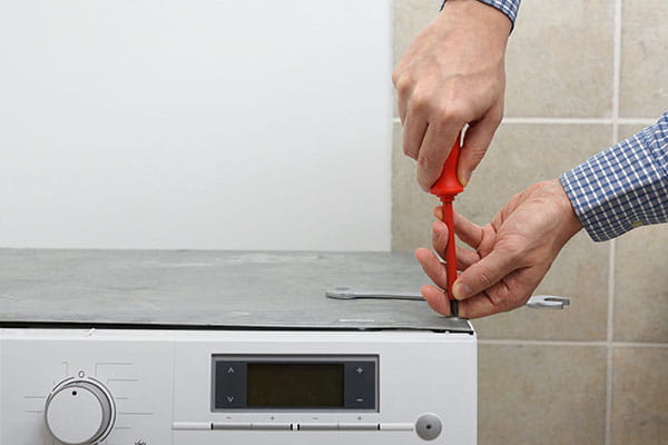 técnico de instalación de lavadora de HomeServe en la cocina de unos clientes