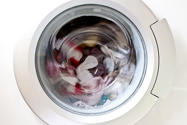Lavadora que no desagua llena de ropa