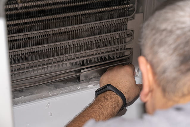 Técnico de HomeServe revisando el ventilador de un frigorífico
