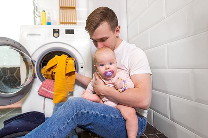 Un padre con su hijo mirando como no gira el tambor de la lavadora