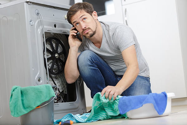 Chico contratando el seguro de electrodomésticos de HomeServe para reparar la lavadora