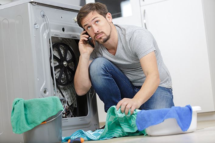 Chico contratando el seguro de electrodomésticos de HomeServe para reparar la lavadora