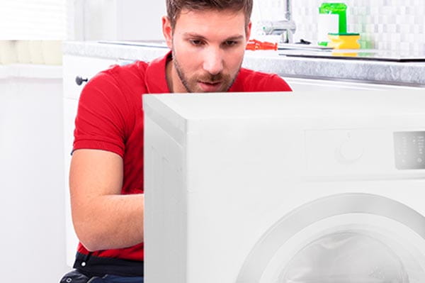 Técnico de electrodomésticos de HomeServe reparando una secadora