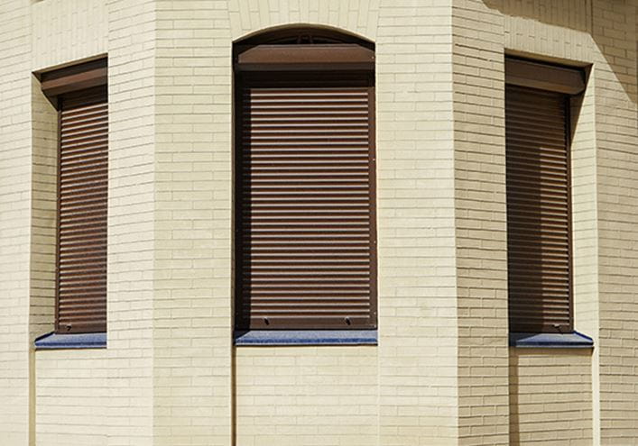 fachada de edificio con tres ventanas que necesitan cambiar la cuerda de la persiana