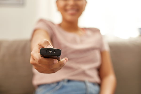 una mujer en su salón sintonizando los canales de tv samsung