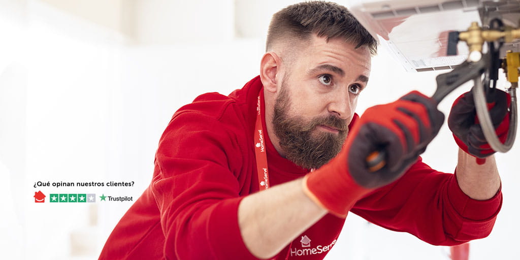 Técnico de HomeServe reparando una caldera con una llave inglesa